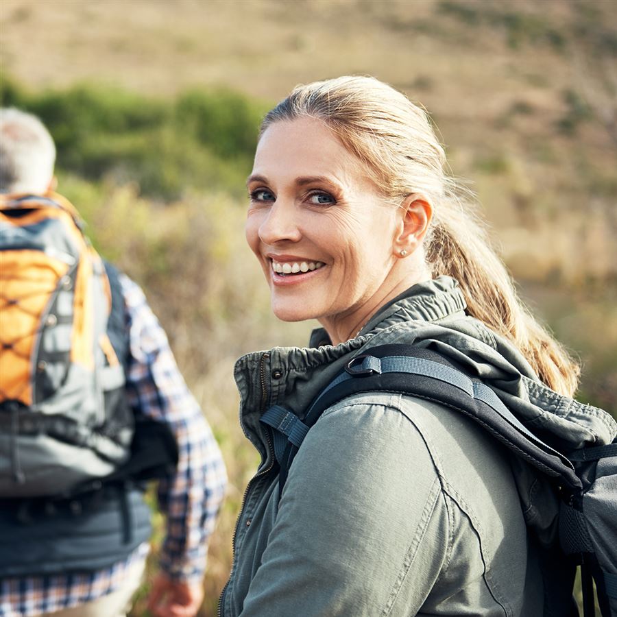 Vrouw aan het wandelen met rugzak in de natuur